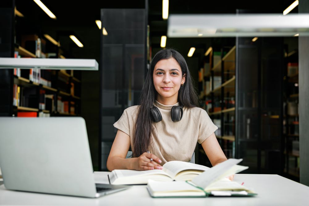 Female student working on her laptop in the library
