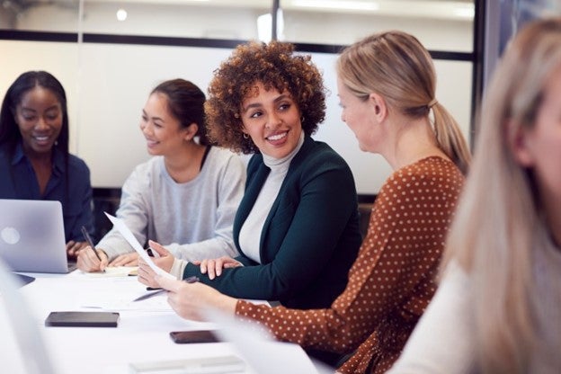 A group of business professionals sit around a conference table. 