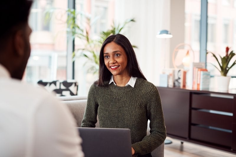 An environmental psychologist smiling and talking with a colleague.