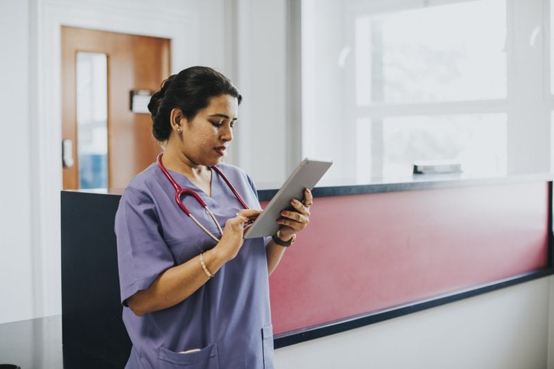 Nurse consults nursing informatics on a tablet.