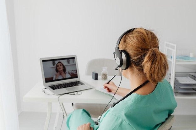 Female healthcare professional consulting with a patient via a video call.