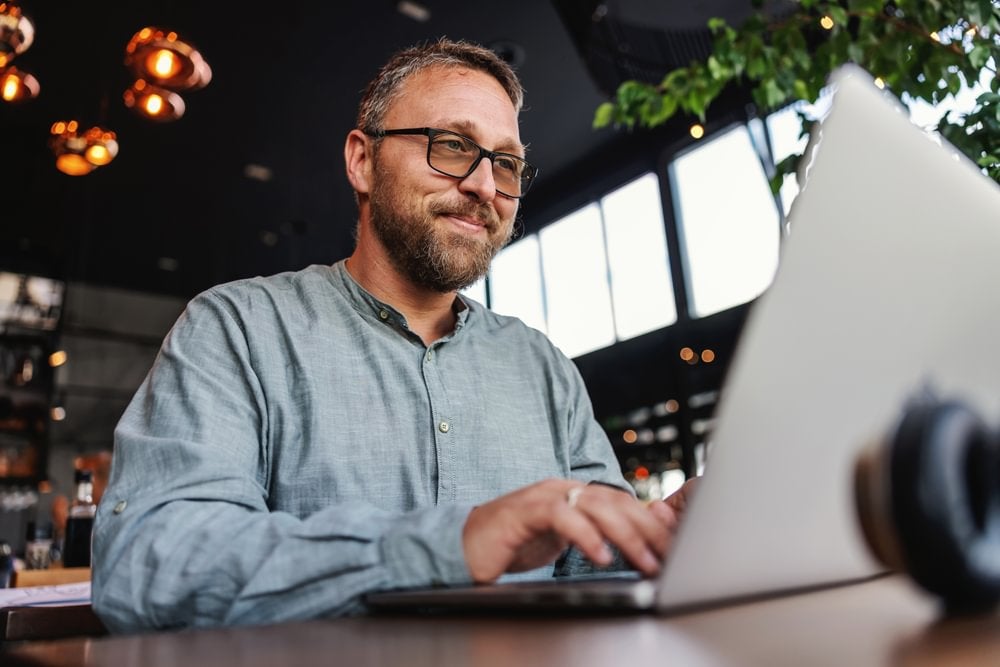 A psychologist smiling and using a laptop.