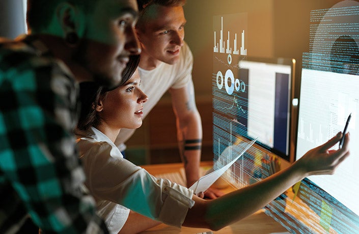 A group of students checking codes on the monitor