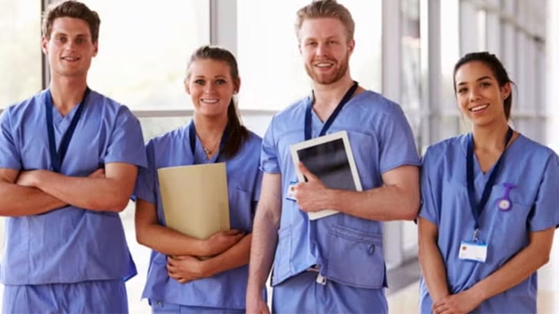 A group of nurses posing together in a hospital environment.