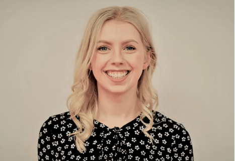 A portrait of a smiling student advisor at JCU, wearing a patterned blouse.