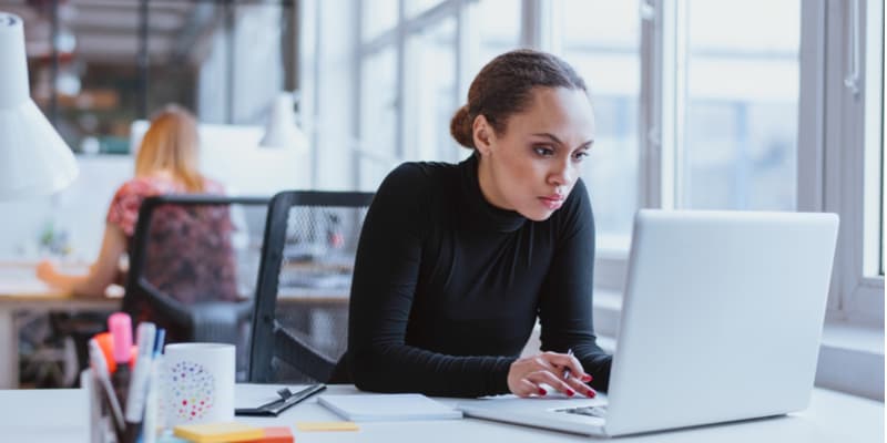 A female data science professional who works for a startup working on her laptop in the office.