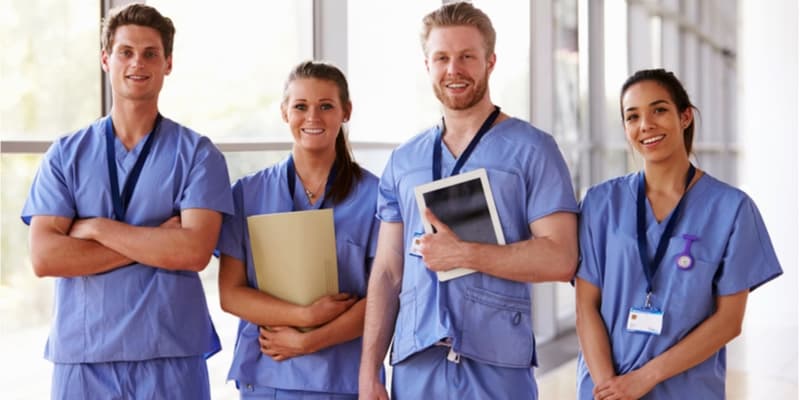 Group portrait of healthcare workers in hospital corridor