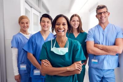 A team of smiling nurses stands together.