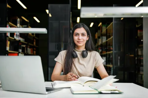 Female student working on her laptop in the library